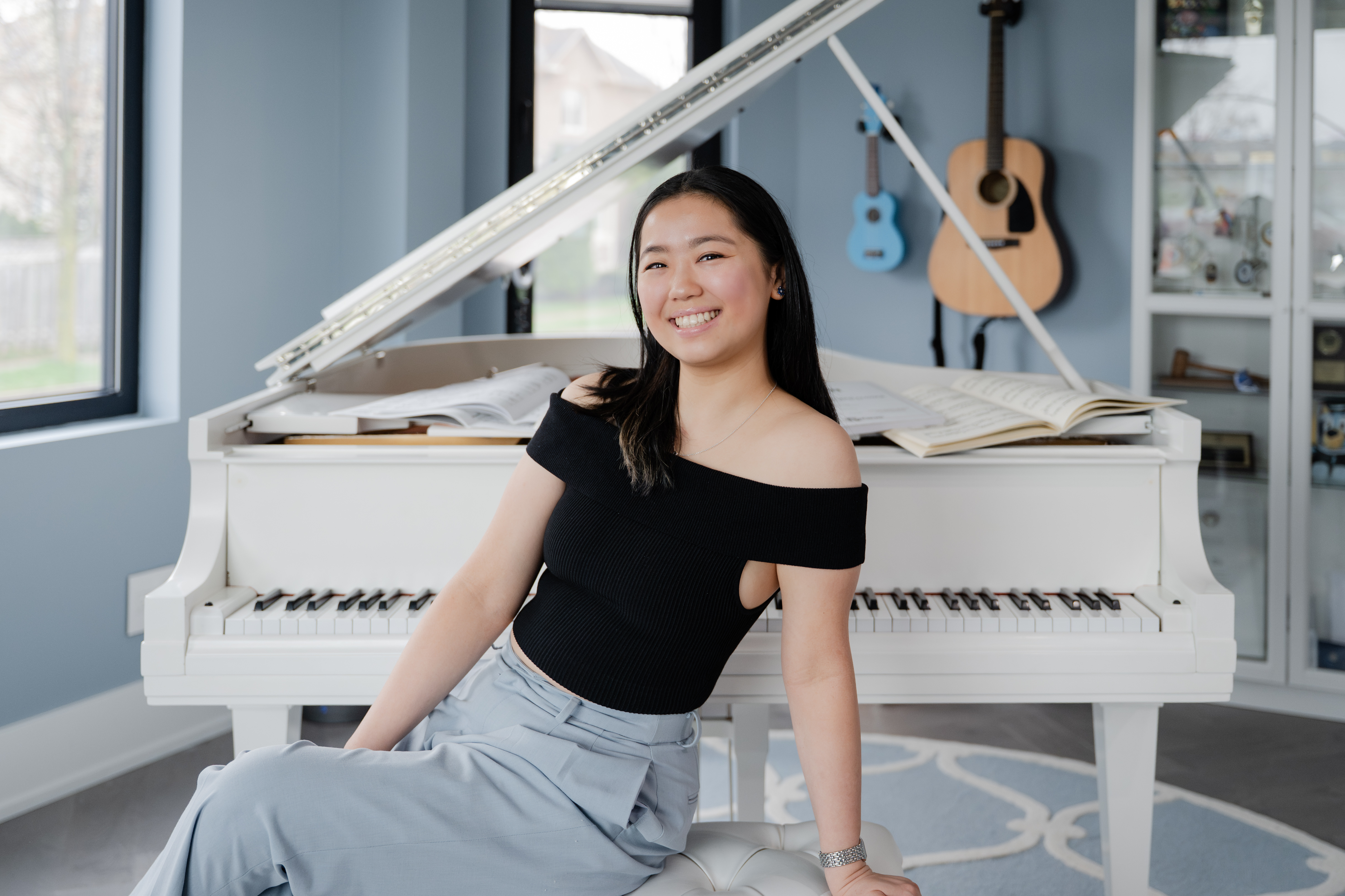 Erin Yip beside a white piano